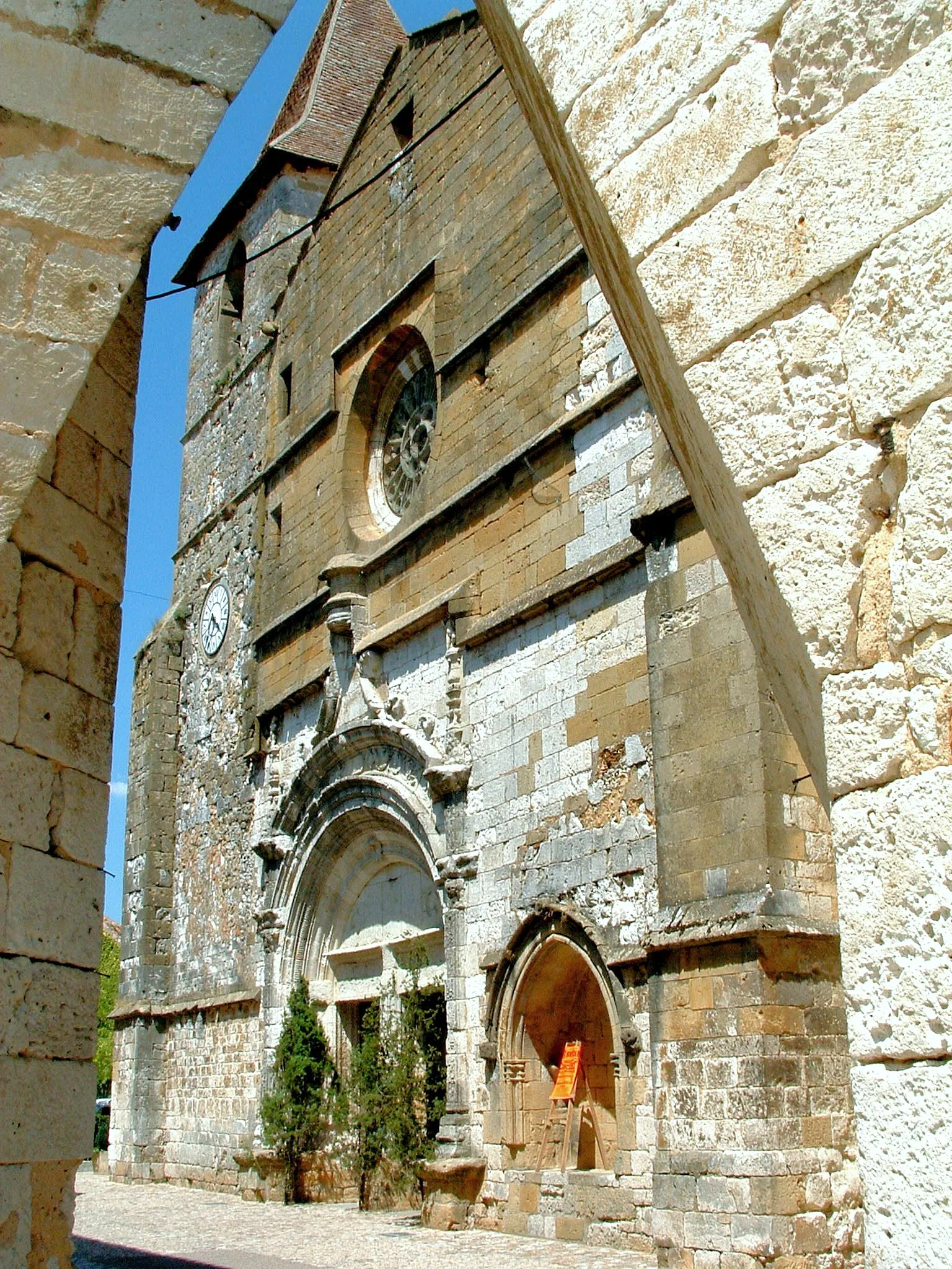 L’église Saint-Dominique vue depuis une arcade de la place des Cornières à Monpazier